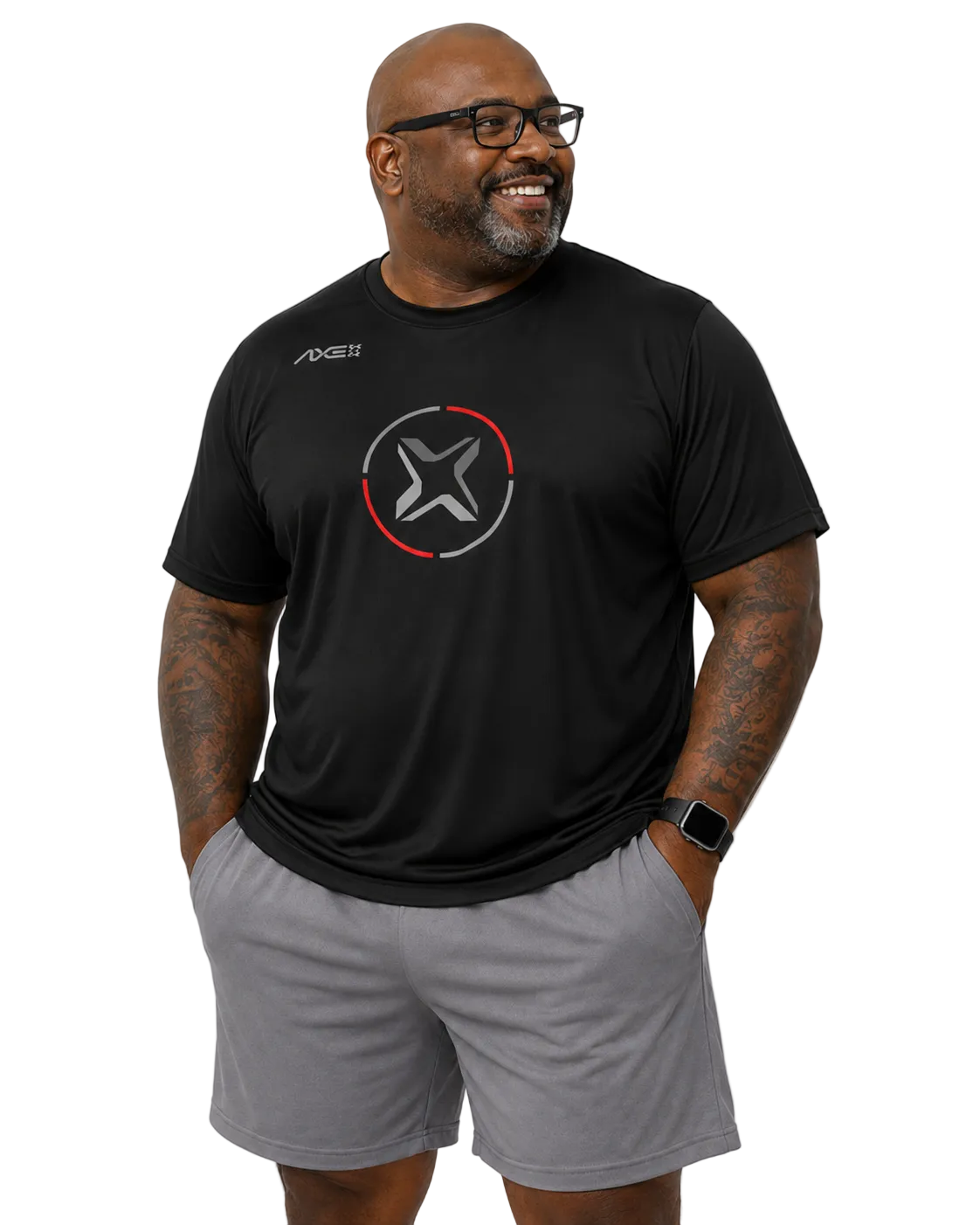 A man wearing a black short-sleeve athletic t-shirt with a circular logo on the chest and gray shorts, standing against a plain white background.
