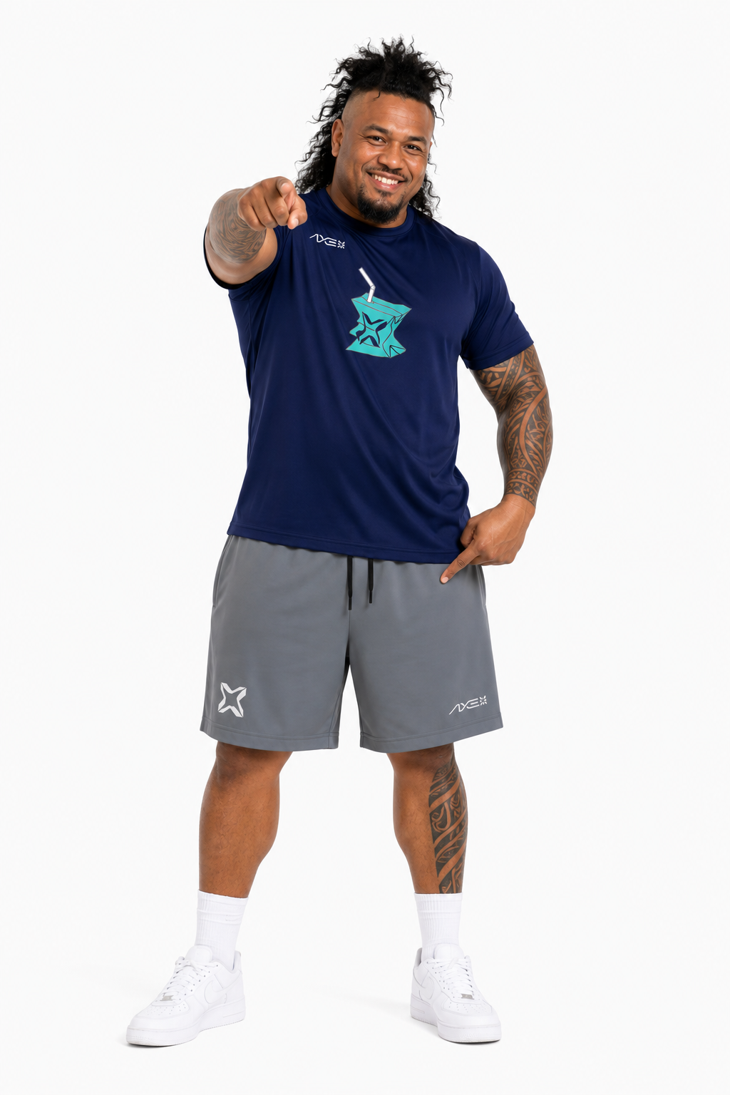 A man modeling a navy blue short-sleeve t-shirt with a teal graphic on the chest and gray athletic shorts, posed against a solid white background.