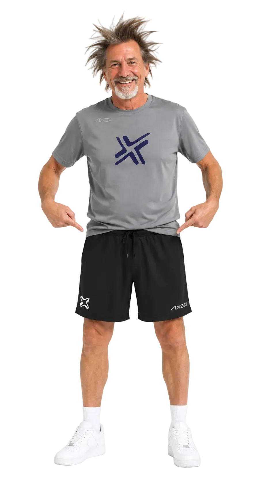 A man modeling a gray athletic t-shirt and black athletic shorts with white sneakers, pointing at the logos on the front of the shirt and shorts against a white background.