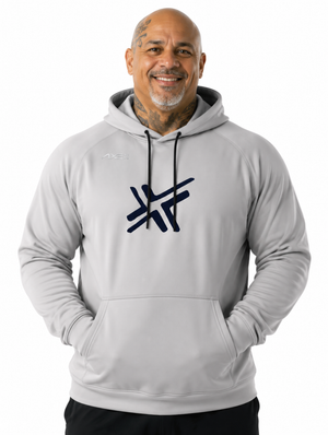 A smiling man wearing a light gray pullover hoodie with a dark navy stylized logo on the chest, photographed against a plain white background.