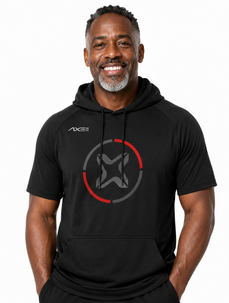 A smiling man wearing a black short-sleeve athletic hoodie with a gray and red circular logo on the chest and a small AXE logo on the right shoulder, photographed against a plain white background.