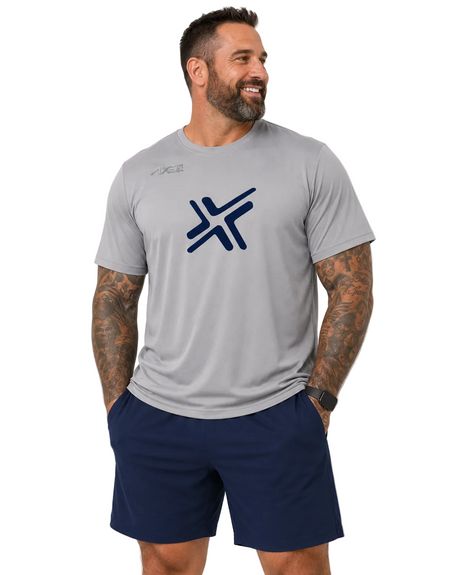 A man wearing a light gray athletic t-shirt with a dark blue stylized 'X' logo on the chest, paired with navy blue shorts, photographed against a light gray studio background.