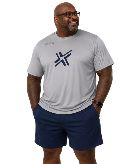 A man wearing a light gray athletic t-shirt with a dark navy blue logo on the chest and matching navy blue athletic shorts, standing against a plain white background.