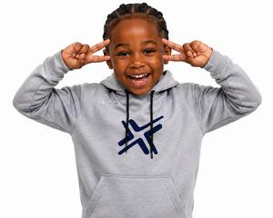 A young boy smiling and posing with his hands on his head, wearing a light gray heathered hoodie with a dark blue graphic logo on the chest. The background is solid white.