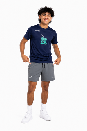 A man modeling a navy blue athletic t-shirt with a teal graphic and gray athletic shorts, paired with white socks and sneakers, against a plain white background.