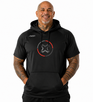A smiling man with tattoos wearing a black short-sleeve athletic hoodie with a red and gray circular logo on the chest and the brand name 'AX3T' on the right shoulder, set against a plain white background.