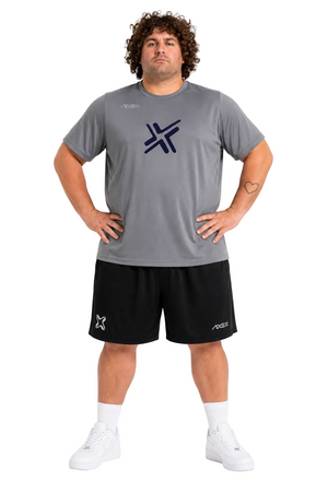 A man modeling a gray athletic t-shirt and black athletic shorts set with white socks and sneakers, featuring a dark navy blue logo on the chest.