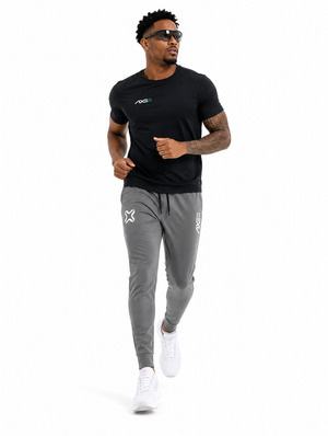 Man running in gray Axe Joggers with the white Axe X mark at the left thigh, paired with a black Axe performance tee.