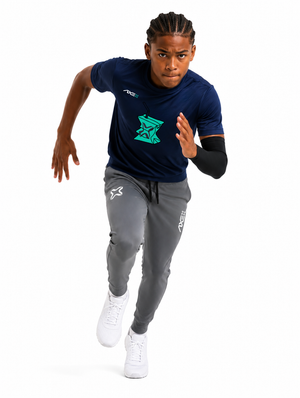 Young ballplayer running in gray youth Axe Joggers with the white Axe X mark at the left thigh, paired with a navy Hit Juice Axe performance tee.