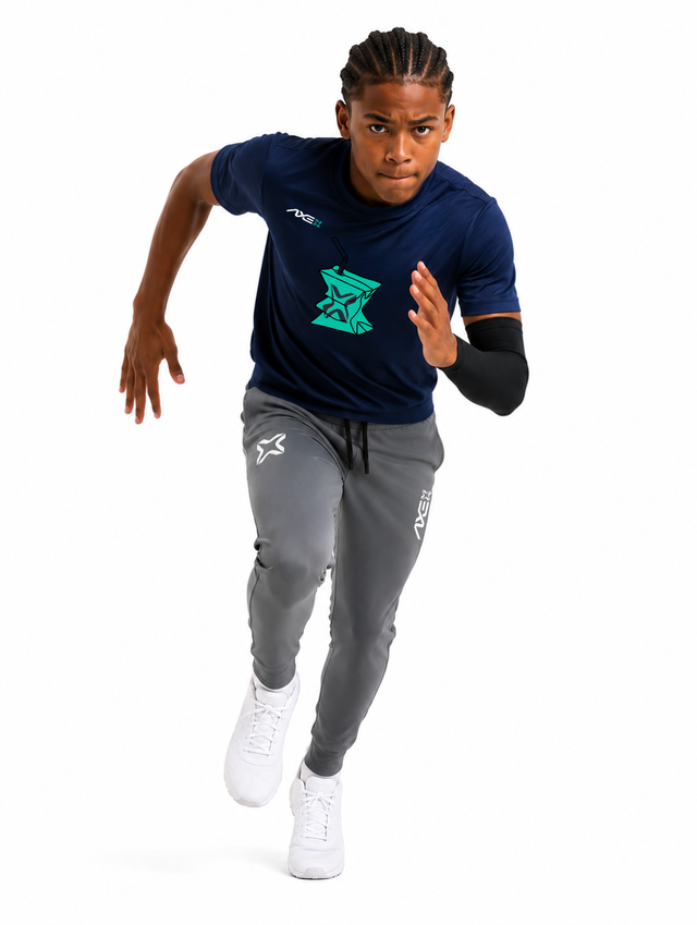 Young ballplayer running in gray youth Axe Joggers with the white Axe X mark at the left thigh, paired with a navy Hit Juice Axe performance tee.